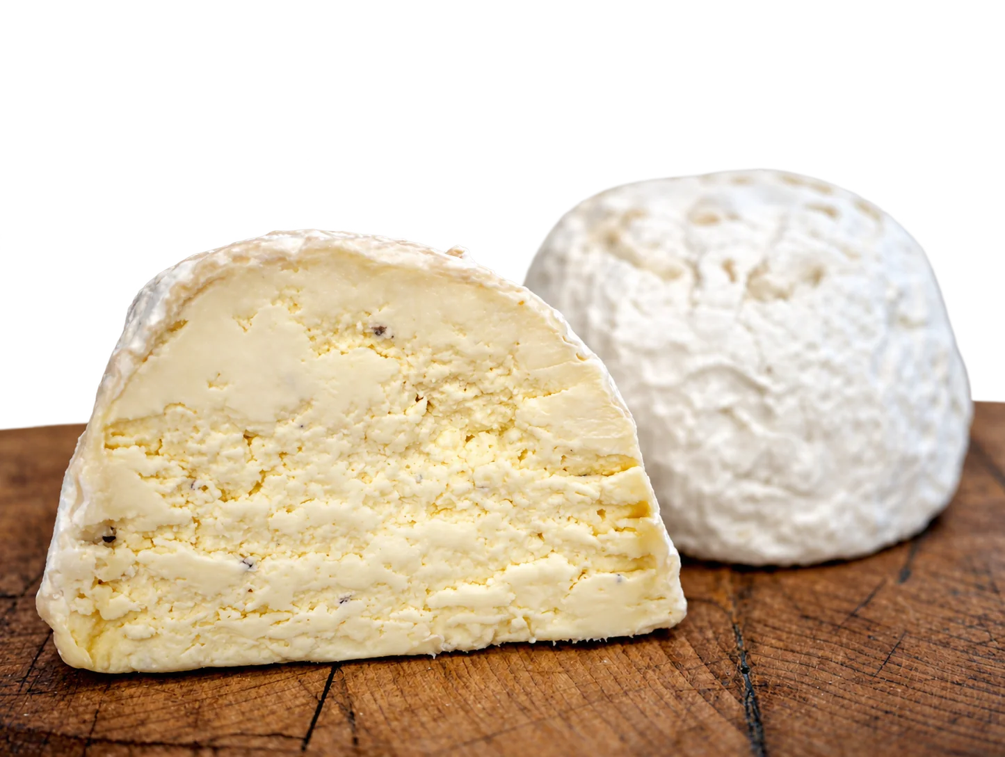 Un fromage coupé à croûte fleurie posé sur une planche en bois, autre vue.